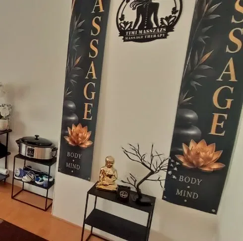 Gold lotus banners and a small golden Buddha in the massage room